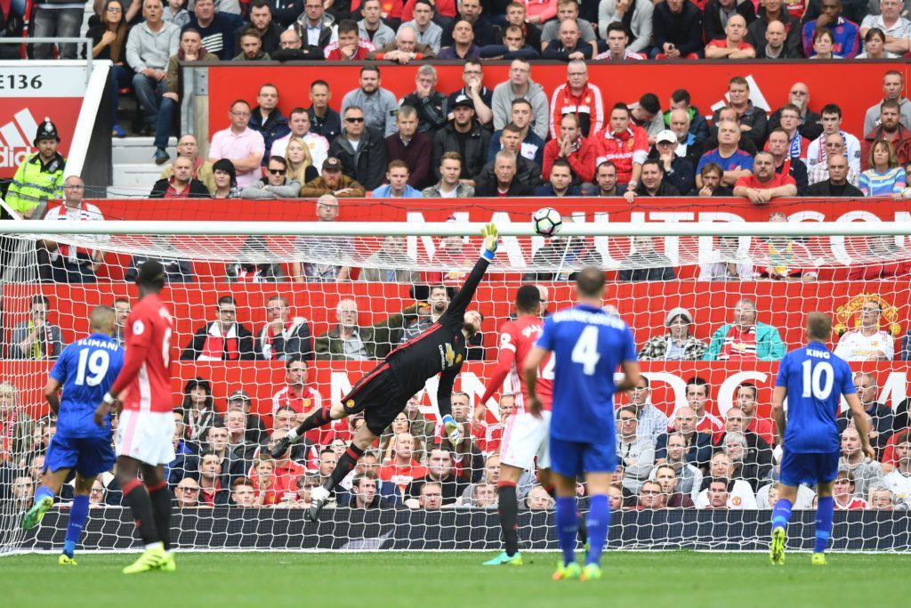 Manchester United's Spanish goalkeeper David de Gea (C) dives in vain to try to keep out a shot from Leicester City's English midfielder Demarai Gray for Leicester's first goal during the English Premier League football match between Manchester United and Leicester City at Old Trafford in Manchester, north west England, on September 24, 2016. / AFP / ANTHONY DEVLIN / RESTRICTED TO EDITORIAL USE. No use with unauthorized audio, video, data, fixture lists, club/league logos or 'live' services. Online in-match use limited to 75 images, no video emulation. No use in betting, games or single club/league/player publications. / (Photo credit should read ANTHONY DEVLIN/AFP/Getty Images)