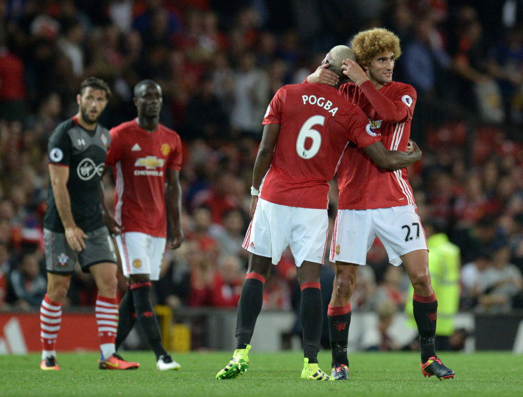 Manchester United's French midfielder Paul Pogba and Manchester United's Belgian midfielder Marouane Fellaini (R) celebrates on the pitch after the English Premier League football match between Manchester United and Southampton at Old Trafford in Manchester, north west England, on August 19, 2016. Manchester United won the game 2-0. / AFP / Oli SCARFF / RESTRICTED TO EDITORIAL USE. No use with unauthorized audio, video, data, fixture lists, club/league logos or 'live' services. Online in-match use limited to 75 images, no video emulation. No use in betting, games or single club/league/player publications.  /         (Photo credit should read OLI SCARFF/AFP/Getty Images)