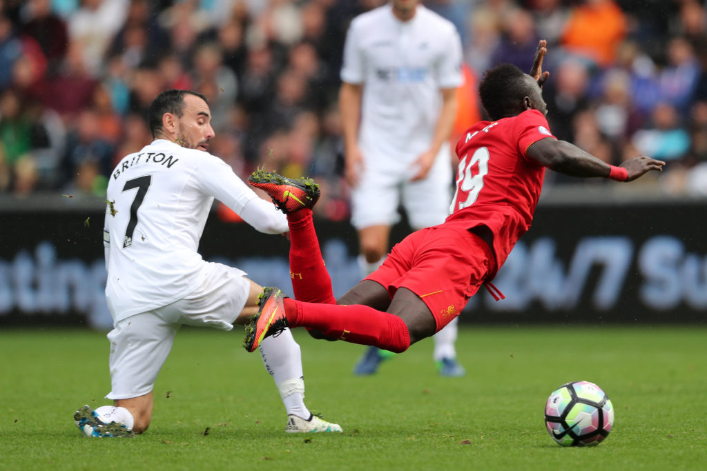 SWANSEA, WALES - OCTOBER 01: Leon Britton of Swansea City fouls Sadio Mane of Liverpool during the Premier League match between Swansea City and Liverpool at Liberty Stadium on October 1, 2016 in Swansea, Wales. (Photo by Matthew Ashton - AMA/Getty Images)