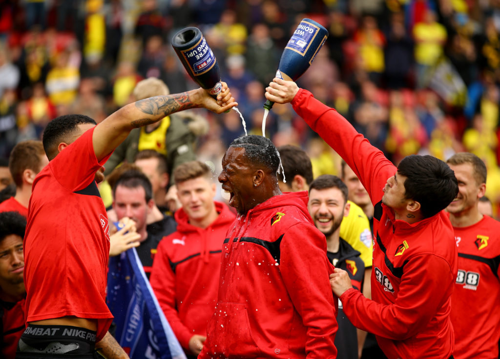 WATFORD, ENGLAND - MAY 02:  Troy Deeney and Fernando Forestieri pour chamagne on Lloyd Doyley as they celebrate promotion to the premier league during the Sky Bet Championship match between Watford and Sheffield Wednesday at Vicarage Road on May 2, 2015 in Watford, England.  (Photo by Richard Heathcote/Getty Images)