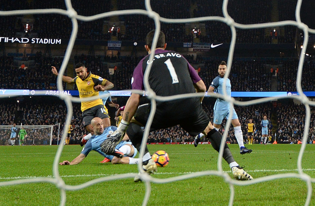 MANCHESTER, ENGLAND - DECEMBER 18: Theo Walcott scores a goal for Arsenal past Claudio Bravo of Man City during the Premier League match between Manchester City and Arsenal at Etihad Stadium on December 18, 2016 in Manchester, England. (Photo by David Price/Arsenal FC via Getty Images)
