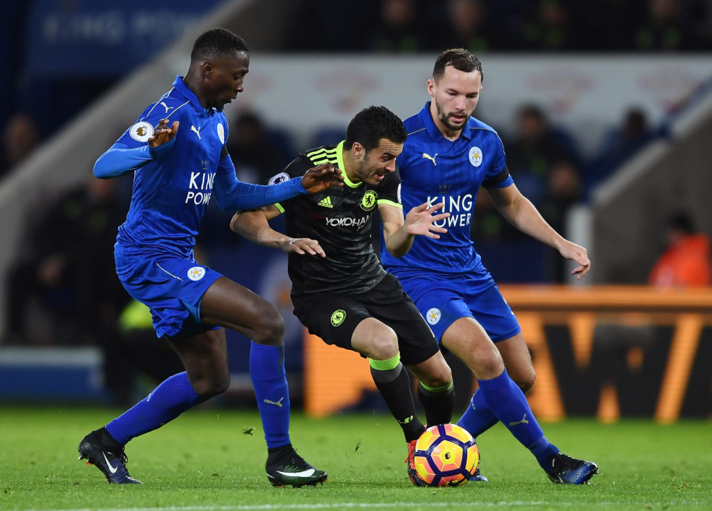 LEICESTER, ENGLAND - JANUARY 14:  Pedro of Chelsea is tackled by Wilfred Ndidi of Leicester City and Danny Drinkwater of Leicester City during the Premier League match between Leicester City and Chelsea at The King Power Stadium on January 14, 2017 in Leicester, England.  (Photo by Laurence Griffiths/Getty Images)