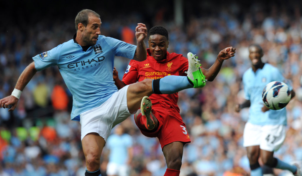 Liverpool's English midfielder Raheem Sterling (C) and Manchester City's Argentian defender Pablo Zabaleta (L) fight for the ball during the English Premier League football match between Liverpool and Manchester City at Anfield in Liverpool, north-west England on August 26, 2012. AFP PHOTO/PAUL ELLIS - RESTRICTED TO EDITORIAL USE. No use with unauthorized audio, video, data, fixture lists, club/league logos or “live” services. Online in-match use limited to 45 images, no video emulation. No use in betting, games or single club/league/player publications.        (Photo credit should read PAUL ELLIS/AFP/GettyImages)